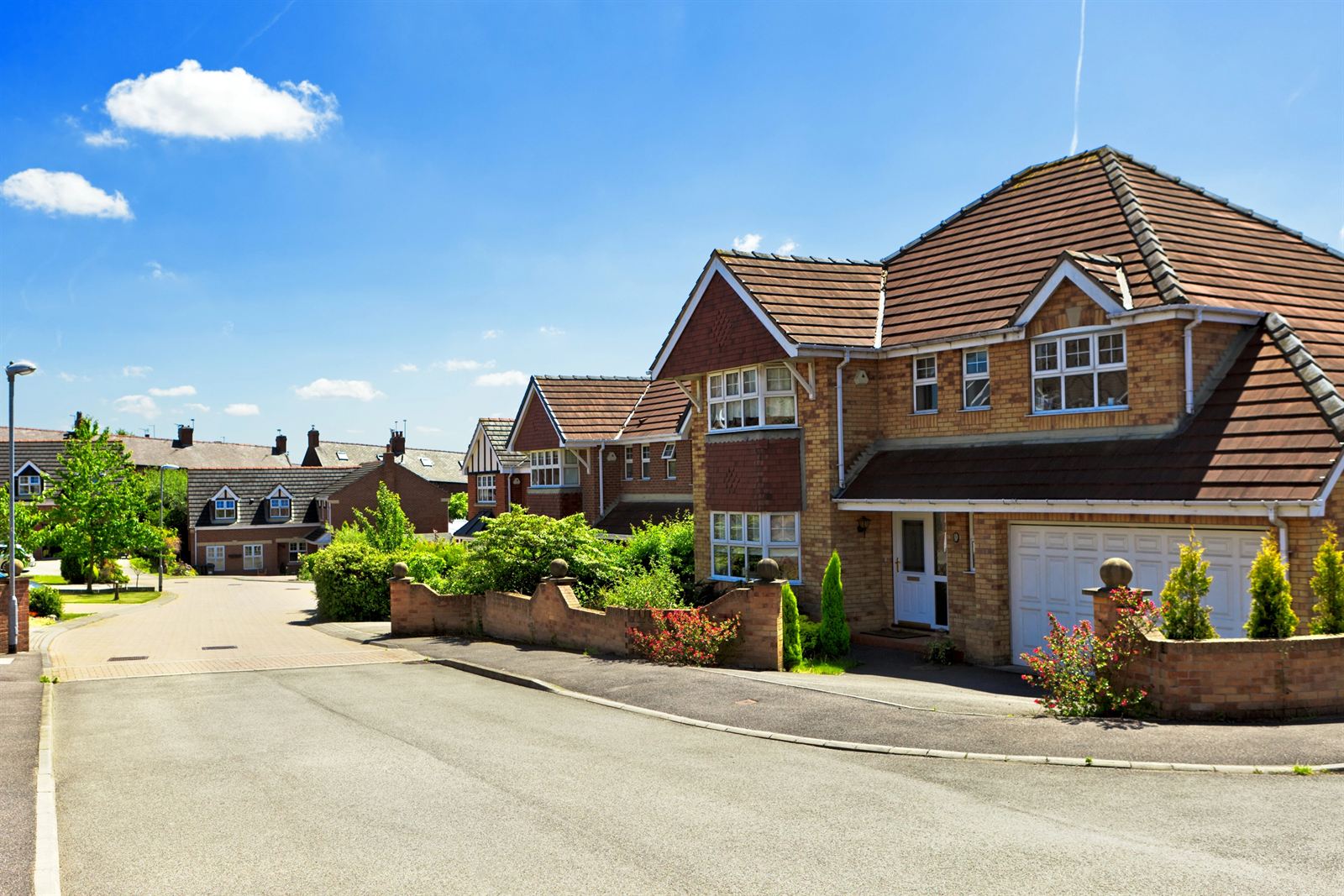 A sunny residential street of brick homes in North London